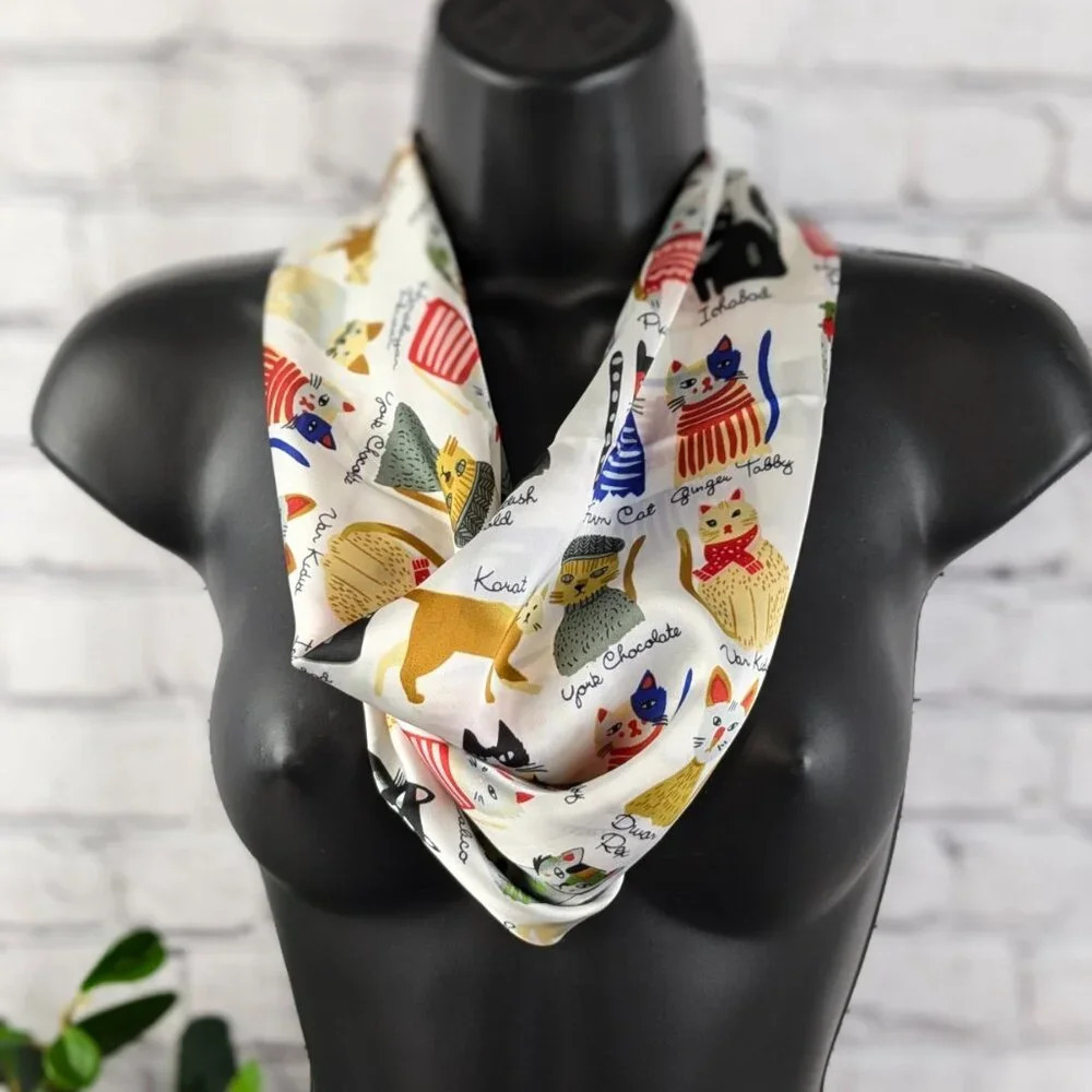 Assorted colorful whimsical cats on white background with gold trim scarf